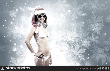 Santa girl. Attractive girl in Santa hat and white bikini against color background