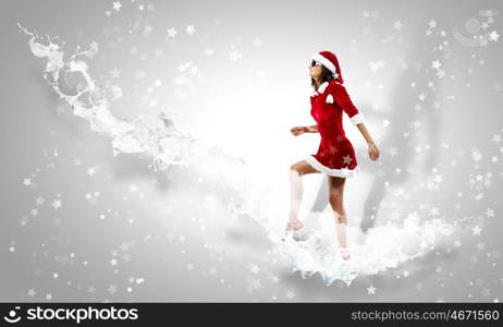 Santa girl. Attractive young woman in Santa suit walking on ladder