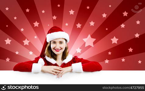 Santa girl with banner. Young attractive woman in santa suit holding blank banner. Place for text