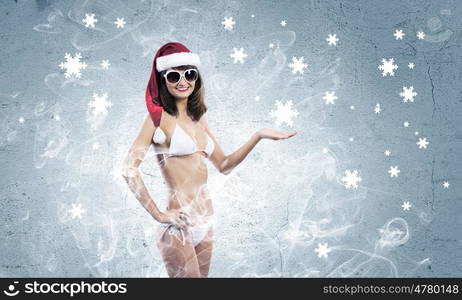 Santa girl. Young woman in swimming suit and santa hat