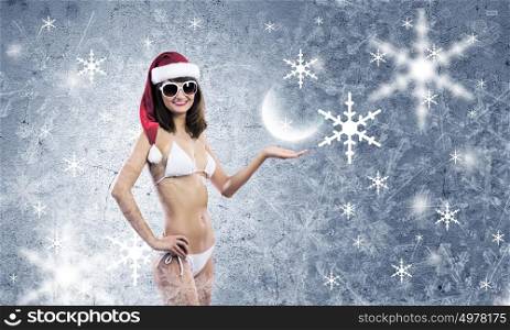 Santa girl. Young woman in swimming suit and santa hat