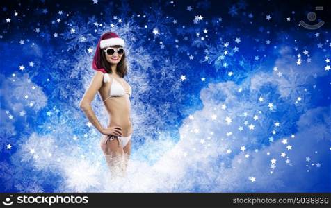 Santa girl. Young woman in swimming suit and santa hat