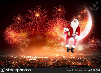 Santa on the moon. Santa Claus on the moon above a city at night