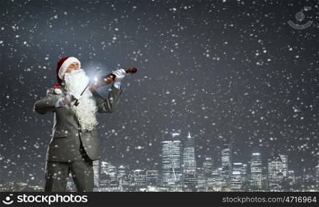 Santa play violin. Businessman in Santa hat and beard playing violin