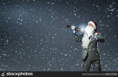 Santa play violin. Businessman in Santa hat and beard playing violin