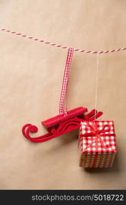 Santa's fairy Christmas decorative sleigh and gift box hanging on a ribbon. Old brown paper background