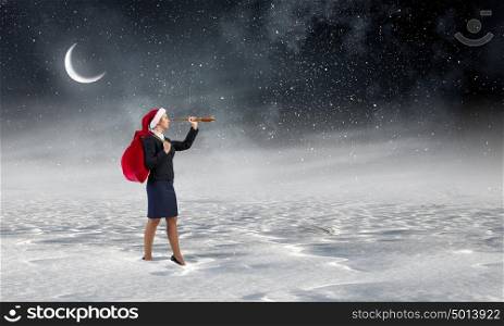 Santa woman in search. Businesswoman in Santa hat on cloud in sky looking in spyglass
