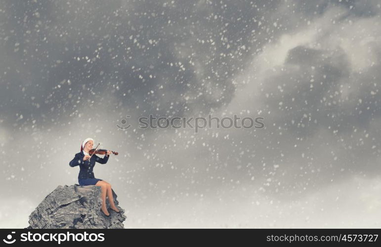 Santa woman play violin. Woman in formal suit and Santa hat playing violin