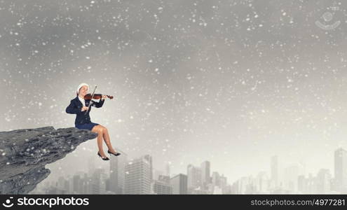 Santa woman play violin. Woman in formal suit and Santa hat playing violin