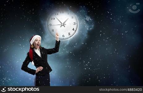 Santa woman. Santa woman pointing on clock with finger