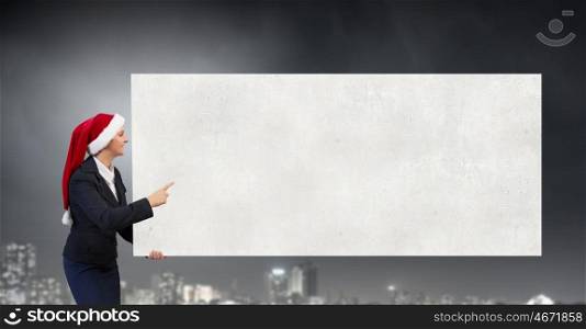 Santa woman with banner. Woman in Santa hat pointing with finger at blank banner. Place for your text