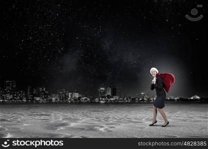 Santa woman with sack. Young businesswoman carrying big heavy Christmas sack on back