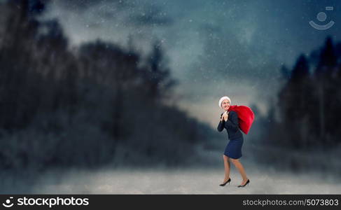 Santa woman with sack. Young businesswoman carrying big heavy Christmas sack on back