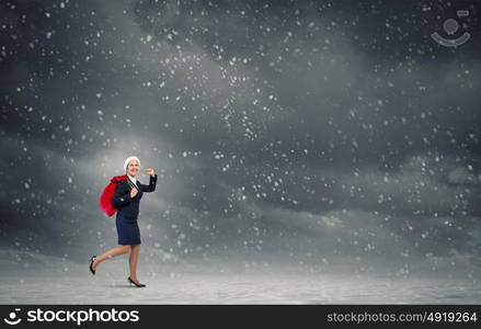 Santa woman with sack. Young businesswoman running big heavy Christmas sack on back