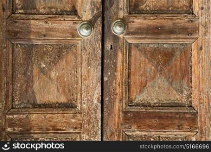 santo antonino abstract samarate rusty brass brown knocker in a door curch closed wood lombardy italy varese