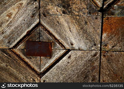 santo antonino abstract samarate rusty brass brown knocker in a door curch closed wood lombardy italy varese