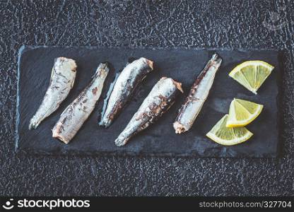Sardines on the black stone board: top view