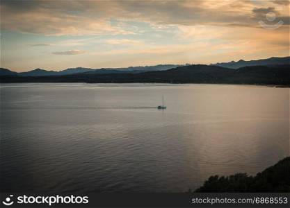 Sardinia Coastline with Hills and White Sailboat at Sunset, Italy