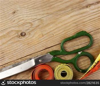 sartorial meter and scissors on the old wooden background