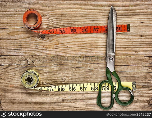 sartorial meter and scissors on the old wooden background