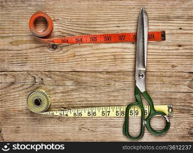 sartorial meter and scissors on the old wooden background