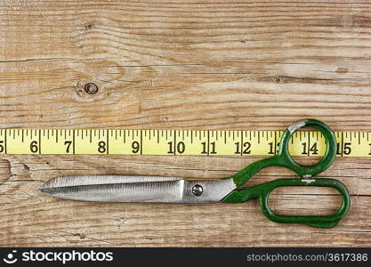 sartorial meter and scissors on the old wooden background