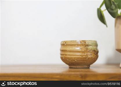 Satai Modern pottery lies on a wooden shelf against a white wall background. Handmade pottery. Thailand&rsquo;s native handicrafts.
