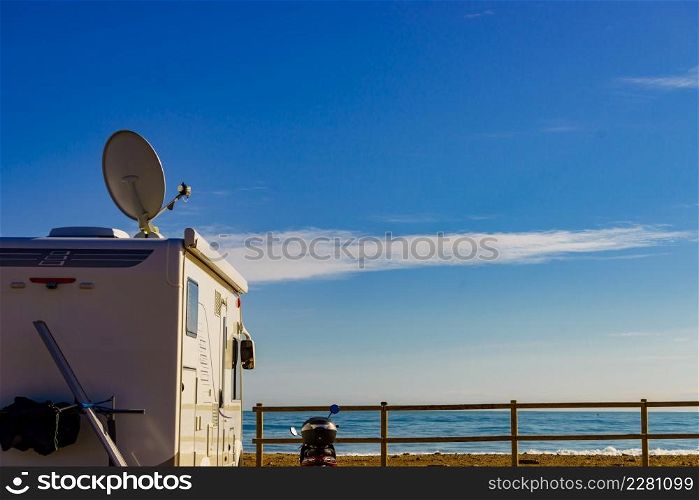 Satellite dish on roof of camper car against blue sky. TV connection. Travel holidays in motor home.. Satellite dish on roof of caravan