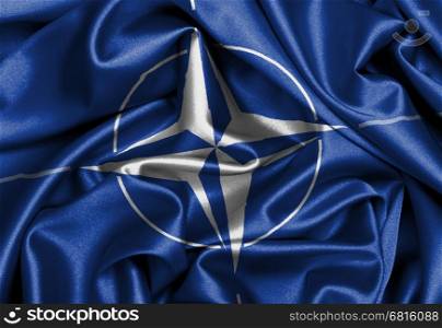Satin flag with emblem, NATO symbol close-up