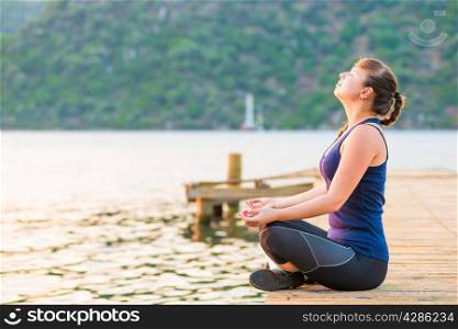 satisfied athlete relaxes on a pier in the morning