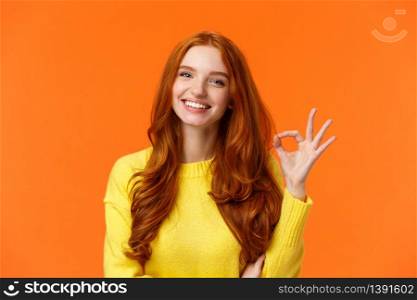 Satisfied consumer recommends product. Cute cheerful feminine redhead woman with pretty smile, showing okay gesture, like, agree or approve something, giving positive feedback, orange background.. Satisfied consumer recommends product. Cute cheerful feminine redhead woman with pretty smile, showing okay gesture, like, agree or approve something, giving positive feedback, orange background