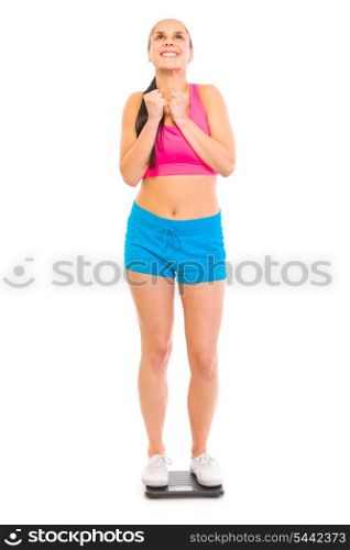 Satisfied with her weight young girl standing on floor scale isolated on white&#xA;
