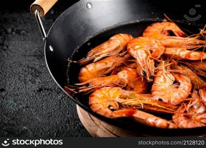 Saucepan with cooked boiled shrimp. On a black background. High quality photo. Saucepan with cooked boiled shrimp.