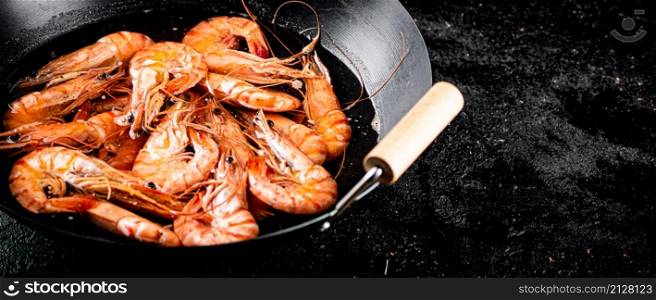 Saucepan with cooked boiled shrimp. On a black background. High quality photo. Saucepan with cooked boiled shrimp.