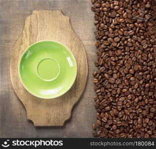 saucer and beans on wooden background, top view