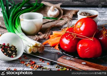 Saucer of pickled tomatoes on wooden background in rustic style. Appetizer with marinated tomatoes