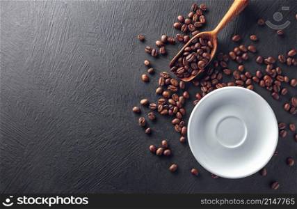 Saucer with beans and wooden scoop on black textured background. Saucer with beans and wooden scoop on dark background