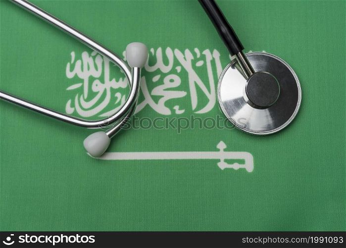 Saudi flag and stethoscope. The concept of medicine. Stethoscope on the flag as a background.. Saudi flag and stethoscope. The concept of medicine.