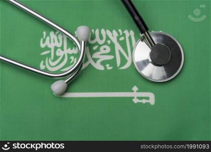 Saudi flag and stethoscope. The concept of medicine. Stethoscope on the flag as a background.. Saudi flag and stethoscope. The concept of medicine.