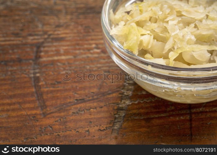 sauerkraut side dish - a glass bowl against rustic wood