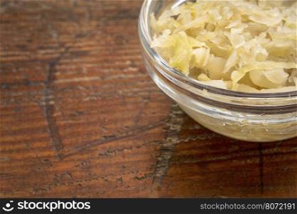 sauerkraut side dish - a glass bowl against rustic wood