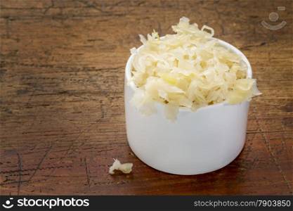 sauerkraut side dish - a white tasting bowl against rustic wood