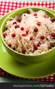 sauerkraut with cranberry in a green bowl. sauerkraut with cranberry
