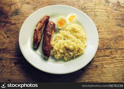 Saurkraut with sausages and boiled eggs on a plate