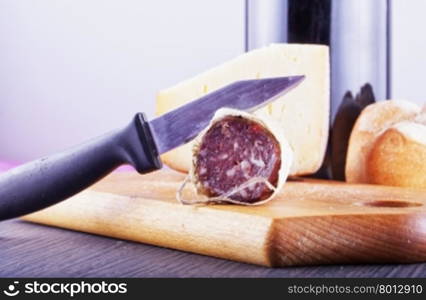 Sausage, cheese, bread and wine on a chopping board, horizontal image