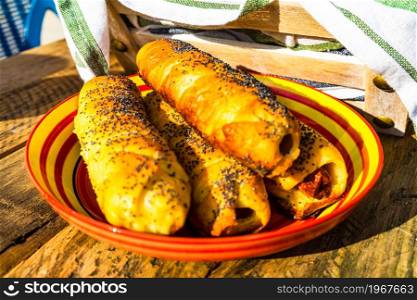 Sausage in puff pastry on a rustic table. Tasty hot dog in pastry