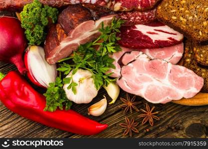 sausage, meat, vegetables and spices on wooden background