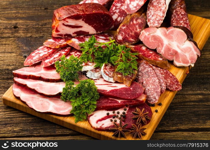 sausage, meat, vegetables and spices on wooden background