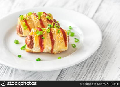 Sausage rolls on the white plate: top view