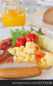 sausage , scrambled eggs , bacon and fresh vegetable salad on dish